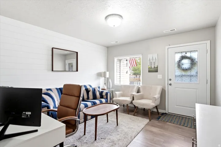 Shiplap accent wall, wood-finish flooring, white entry door with privacy glass, recessed lighting, and a flush-mount ceiling light fixture