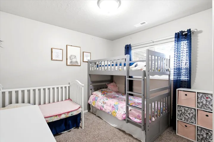 Neutral wall color, wall-to-wall carpeting, window with blinds, and flush mount lighting