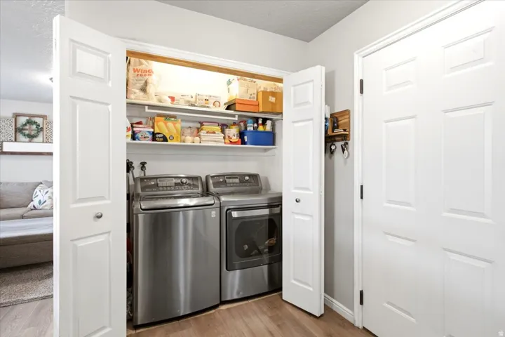 Laundry area with built-in shelving and wood-finish flooring