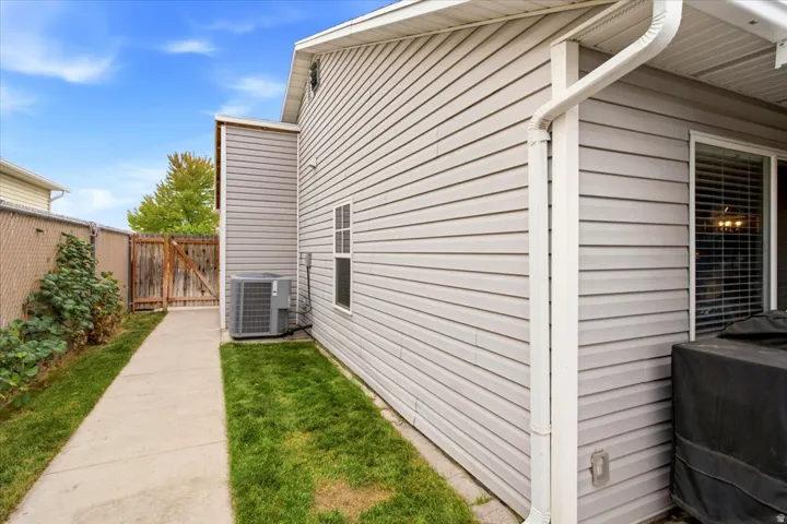 Siding exterior with a concrete pathway and grass strip