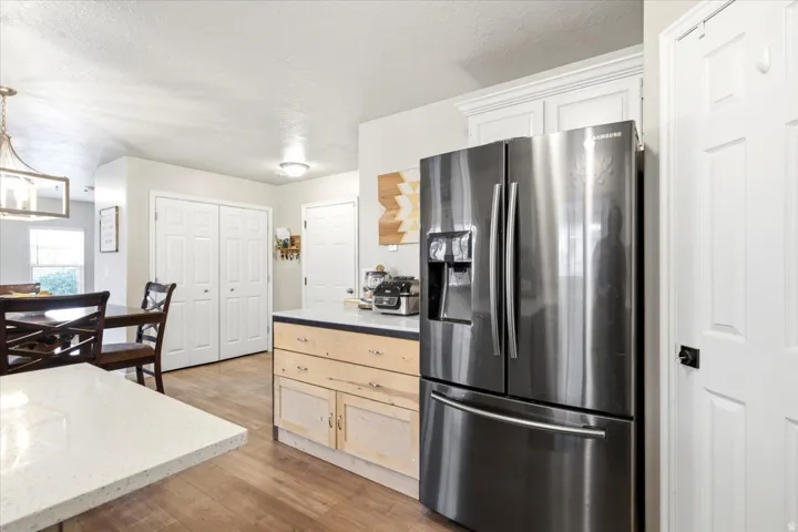 Kitchen featuring wood-finish flooring, white cabinetry, and a light-toned countertop