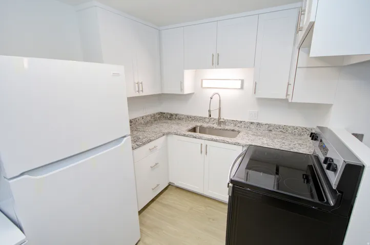 White cabinetry with brushed nickel hardware, granite-style countertops, stainless steel sink with gooseneck faucet, black electric range, and wood-finish flooring