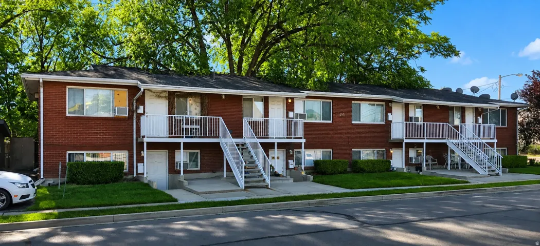 Brick exterior construction with multiple private balconies, individual entryways, and separate outdoor staircases