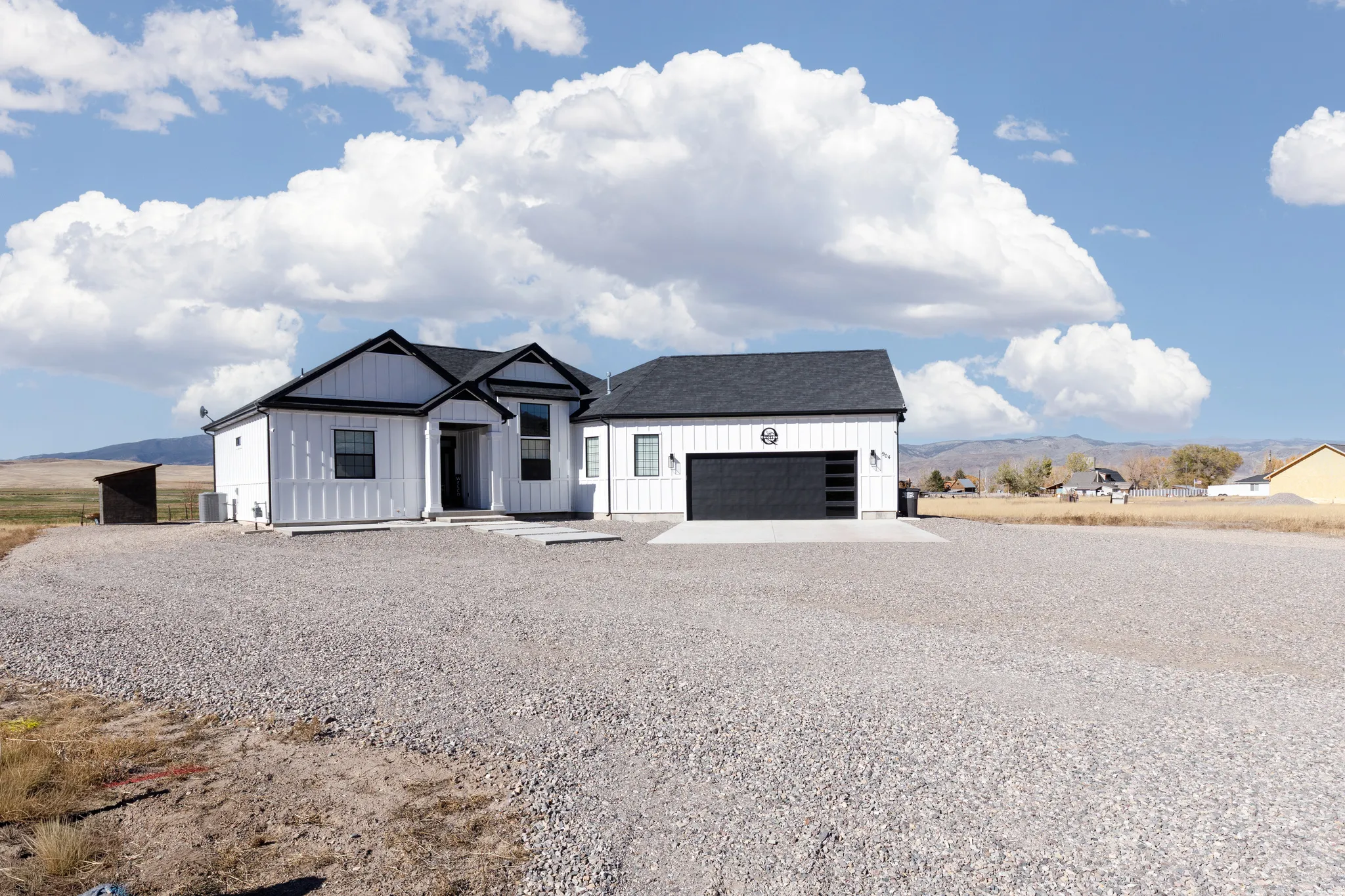 White board and batten exterior with black trim accents and a dark-toned roof