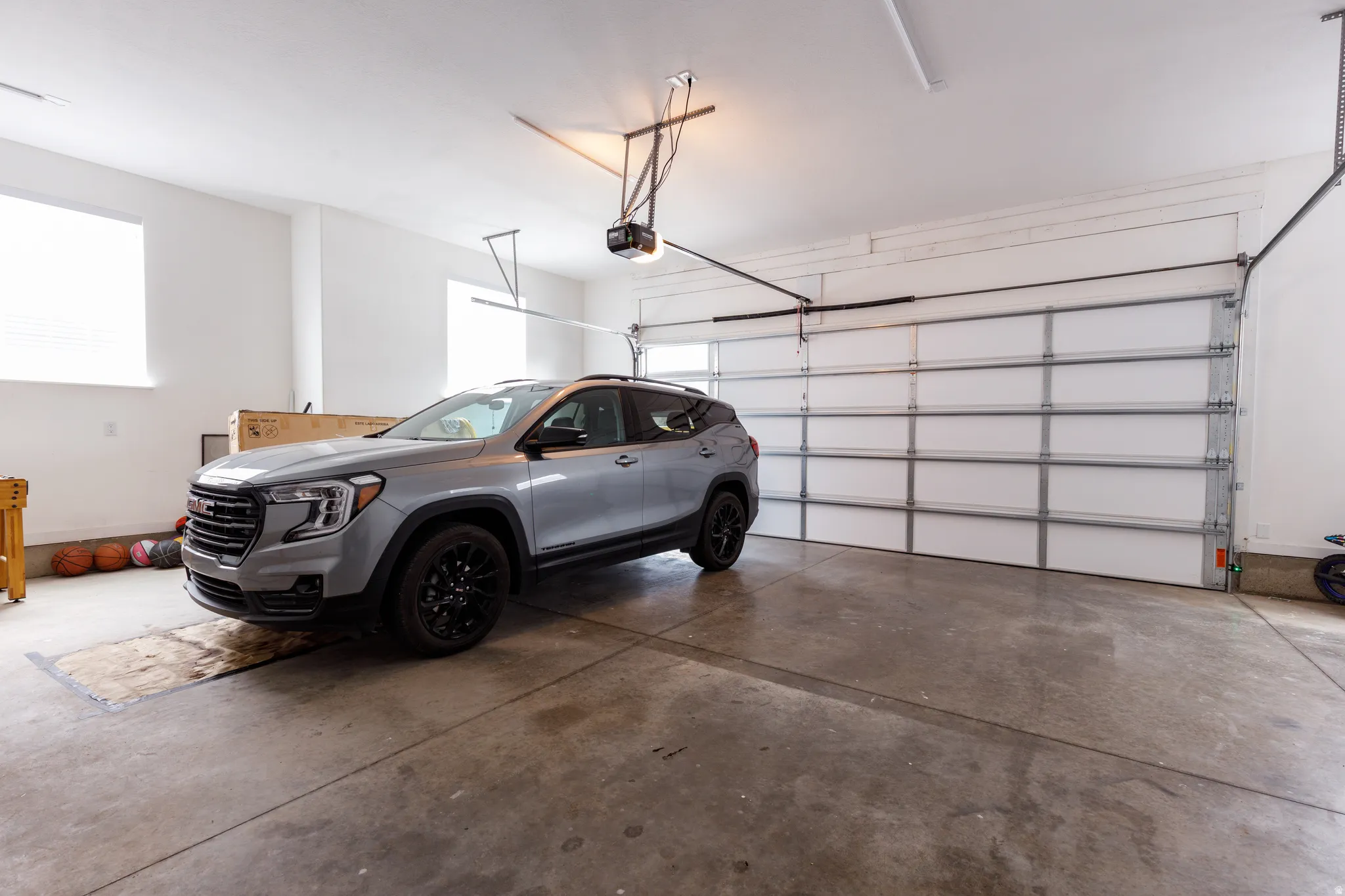 Spacious garage with concrete flooring, automatic garage door, and recessed lighting