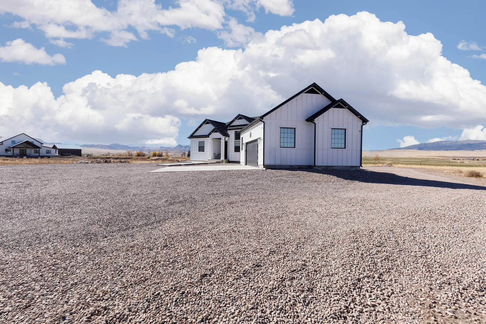 Modern farmhouse architecture with white vertical siding and black roof accents