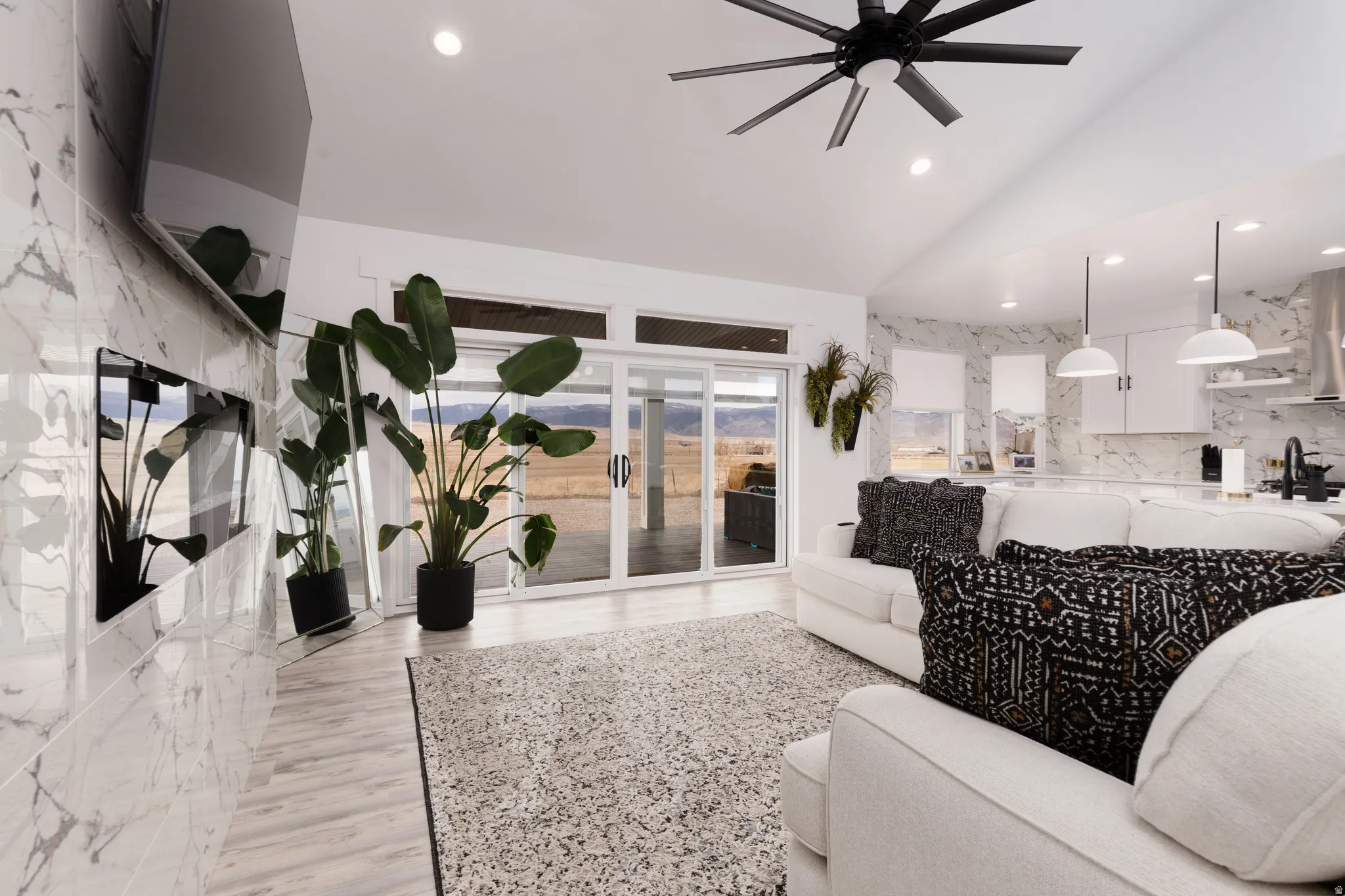 Vaulted ceilings, wood-finish flooring, recessed lighting, and a contemporary ceiling fan