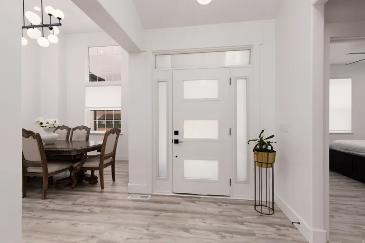 Entryway featuring a contemporary door with frosted glass panels, wood-finish flooring, and a sidelight