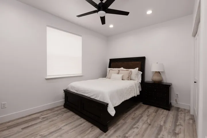 Wood-finish flooring, recessed lighting, and a ceiling fan with integrated lighting