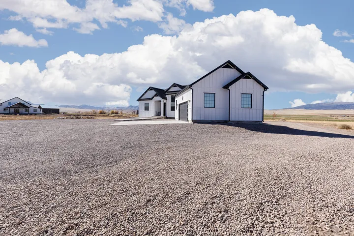 Modern farmhouse architecture with white vertical siding and black roof accents
