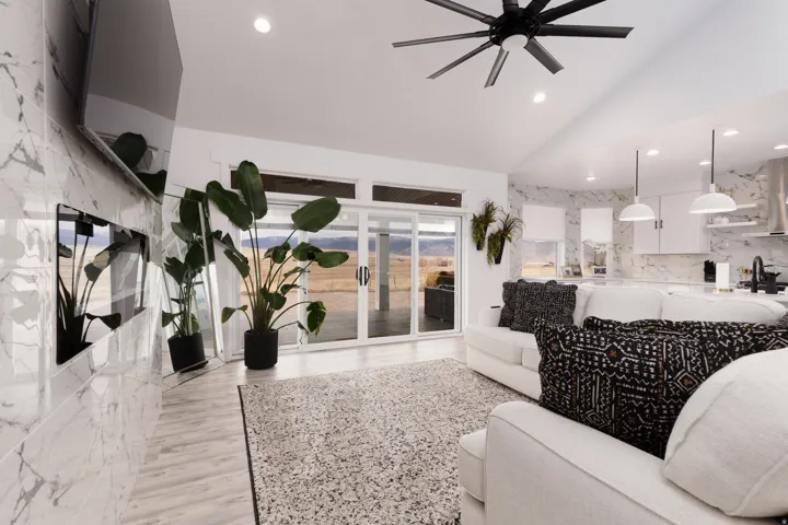 Vaulted ceilings, wood-finish flooring, recessed lighting, and a contemporary ceiling fan