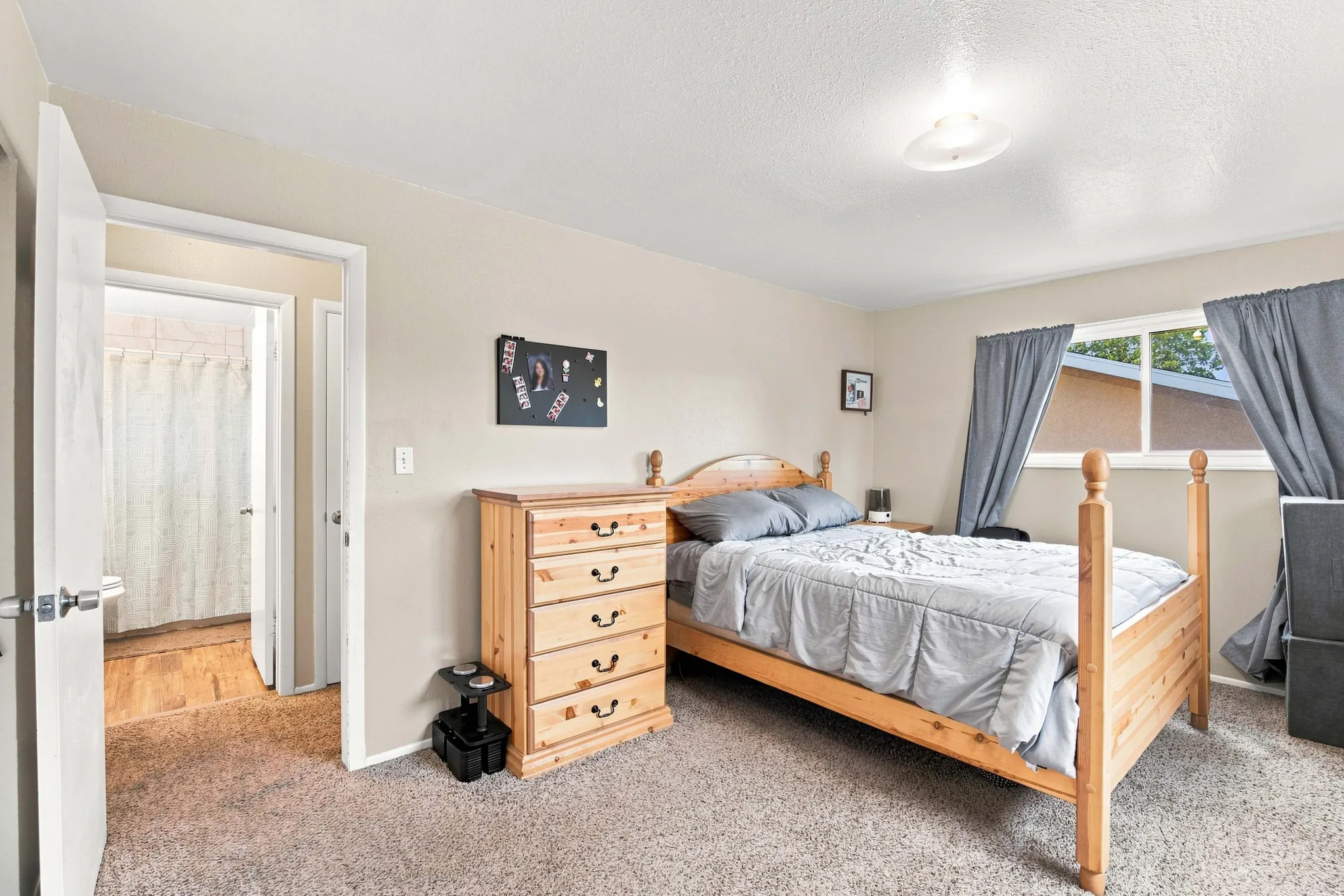 Wall-to-wall carpeting with neutral wall tones and a window with natural light