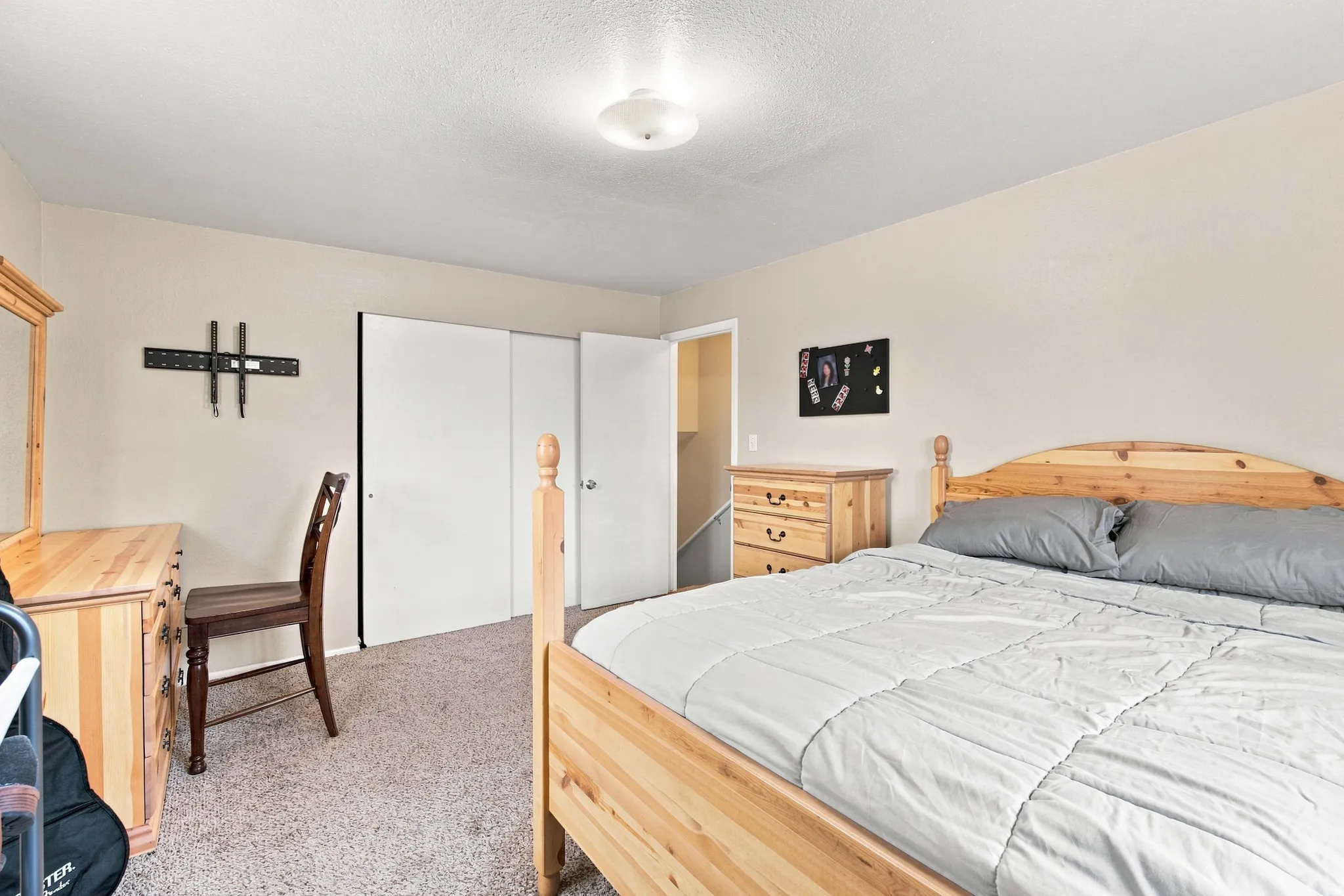 Neutral tone wall paint, textured ceiling, flush mount ceiling light fixture, and carpet flooring