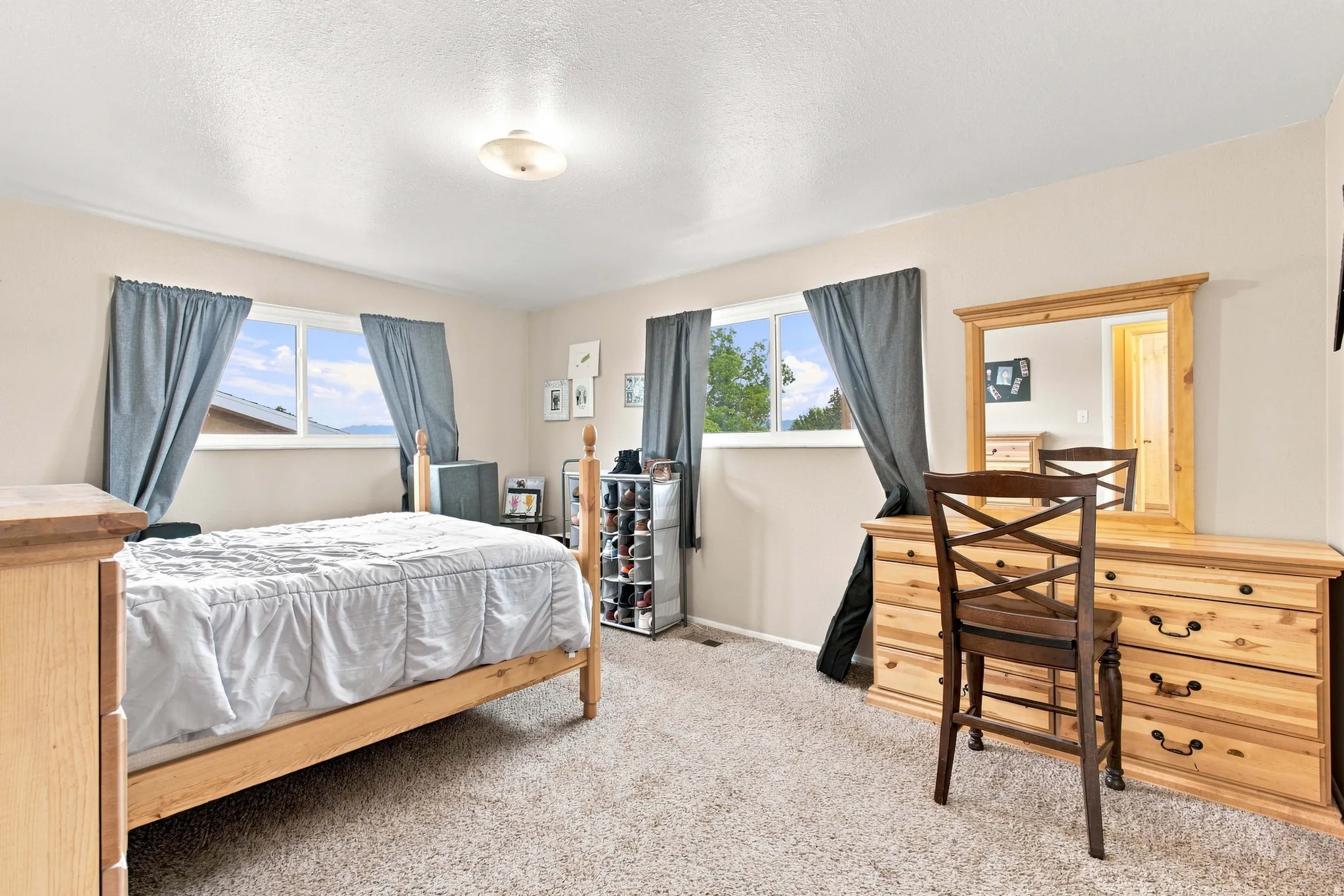 Neutral wall color with two windows and carpeted flooring