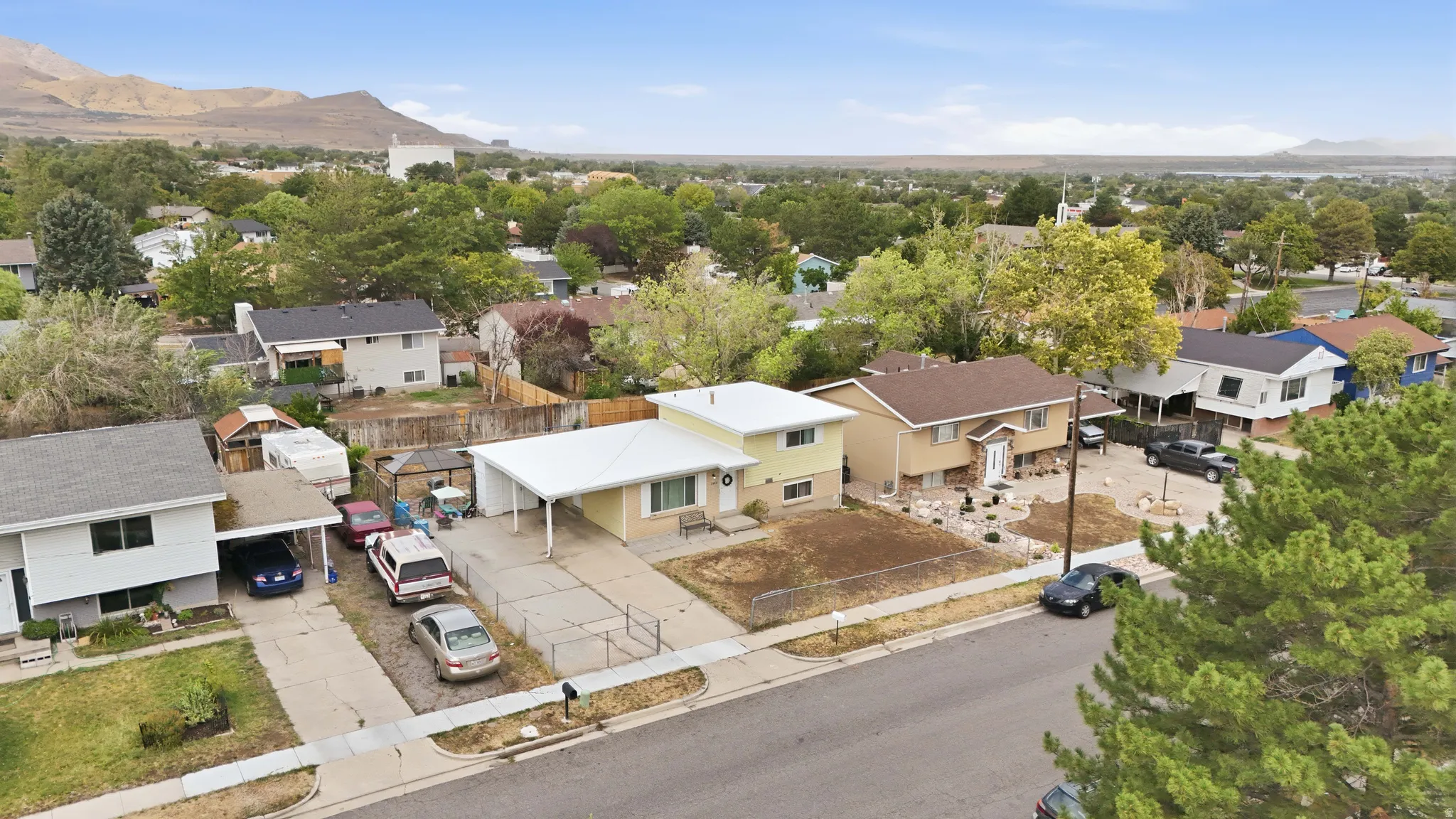 Neighborhood setting with mature trees and mountain backdrop