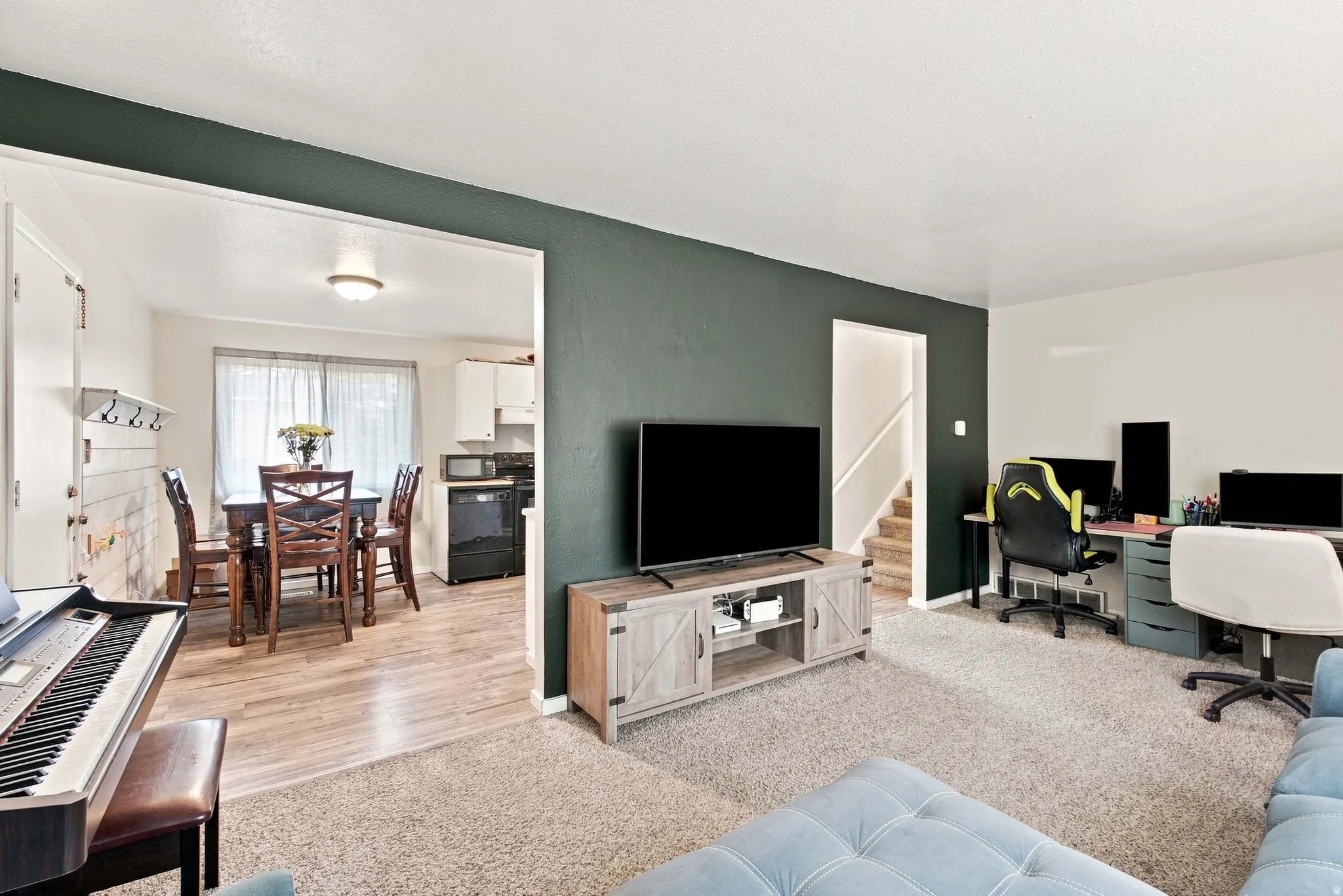 Carpeted living area with accent wall and open archway