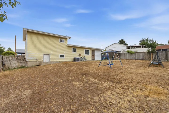 Expansive backyard area with a partial wood fence