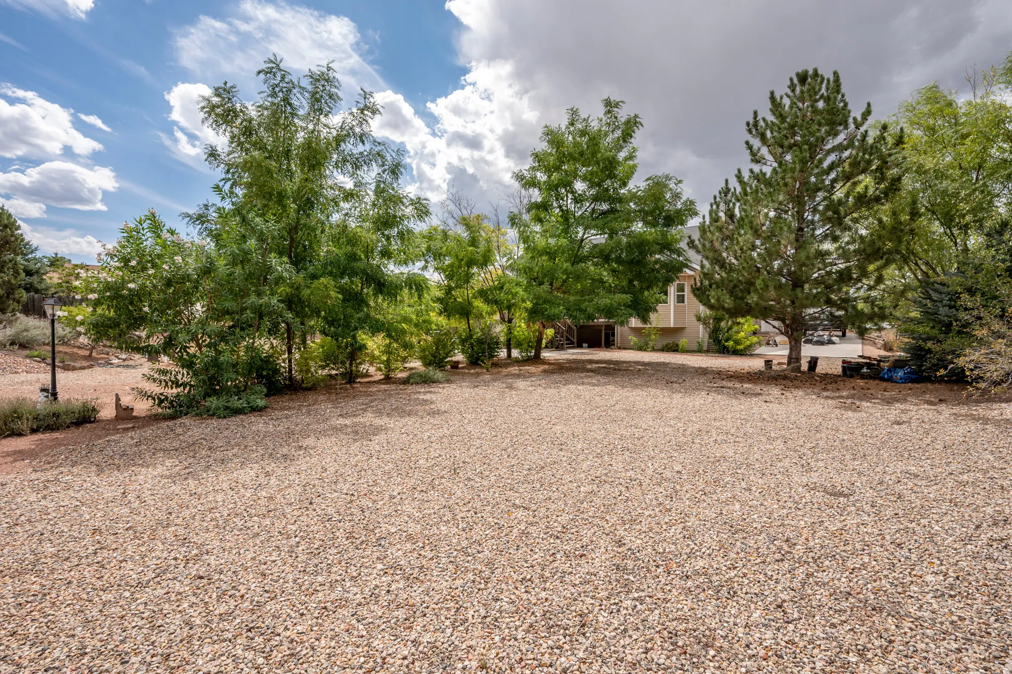 Gravel ground cover with mature trees and landscaping