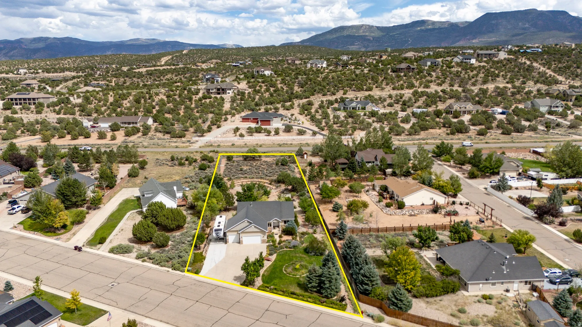 Single-story residence with an attached two-car garage, mature landscaping, and a paved driveway