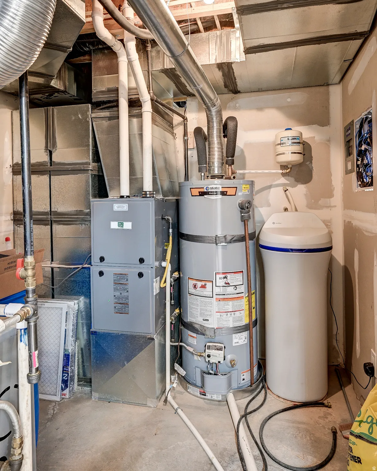 Mechanical room featuring a water heater, furnace, and water filtration system