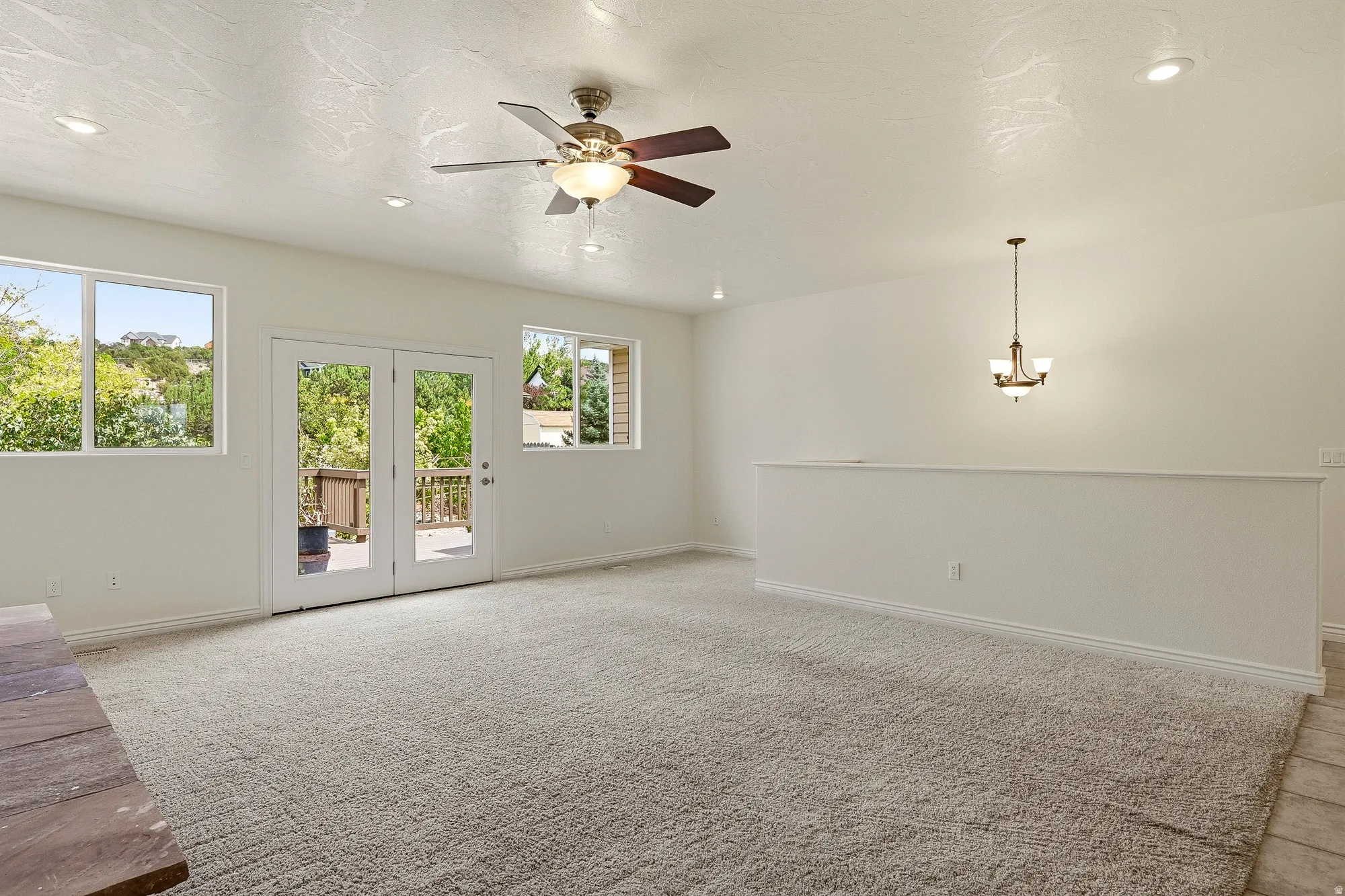 Bright living area featuring carpet flooring, recessed lighting, and a ceiling fan