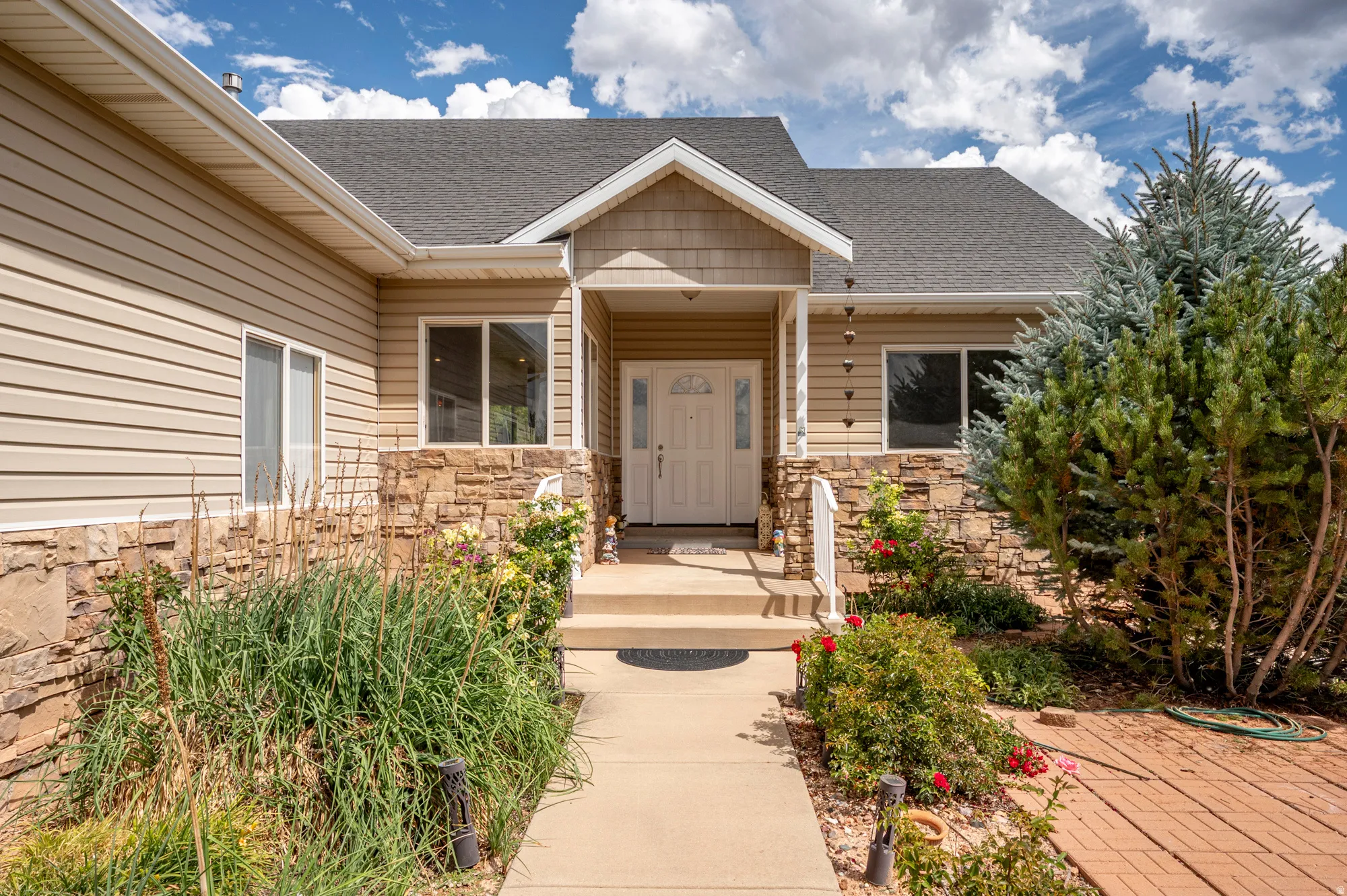 Entryway featuring a covered porch, stone veneer siding, horizontal siding, and a shingled roof