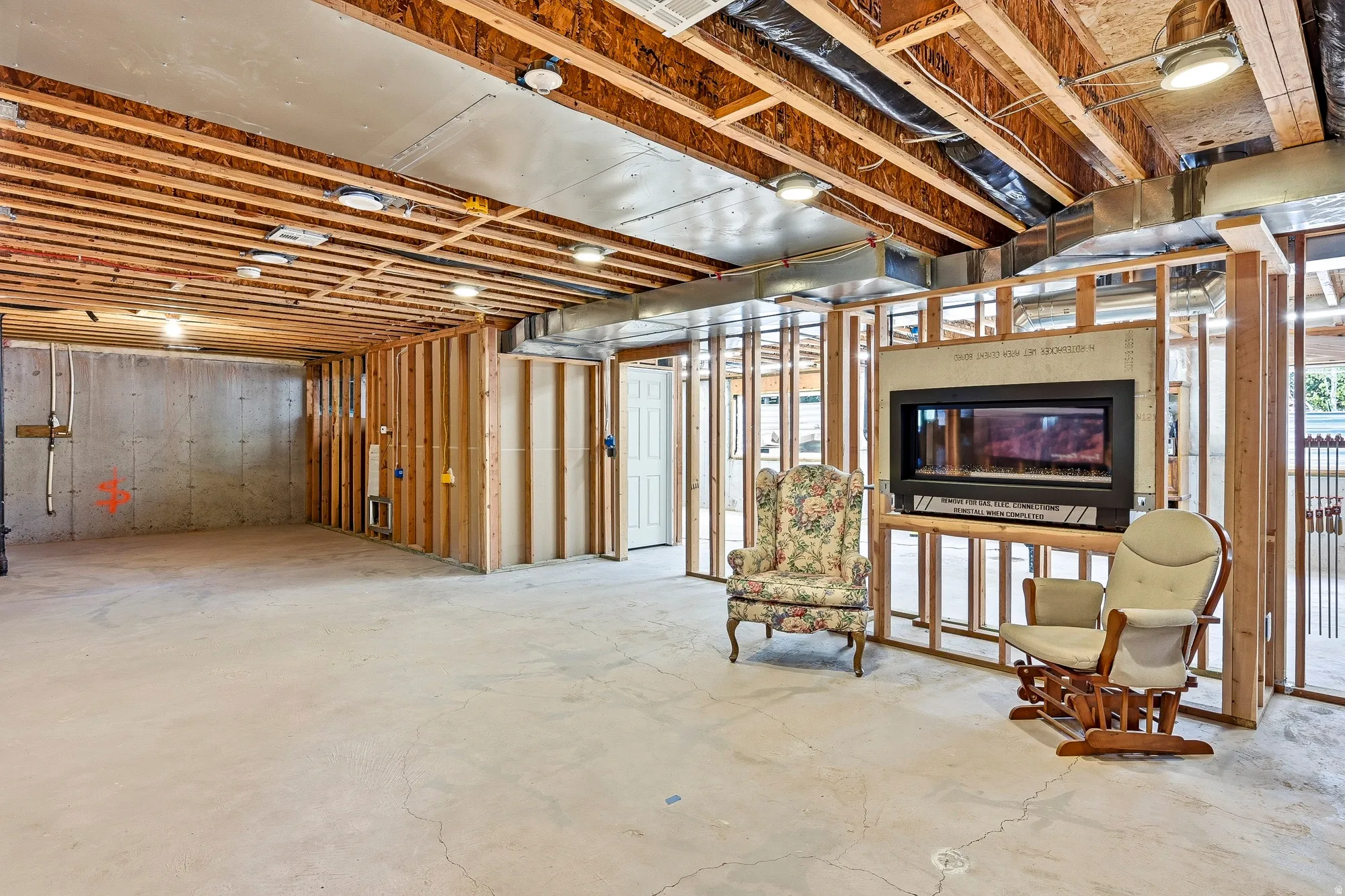Framed interior with exposed ceiling joists and a built-in fireplace feature