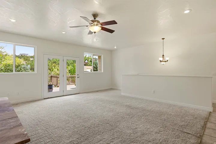 Bright living area featuring carpet flooring, recessed lighting, and a ceiling fan