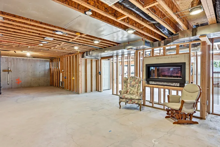 Framed interior with exposed ceiling joists and a built-in fireplace feature
