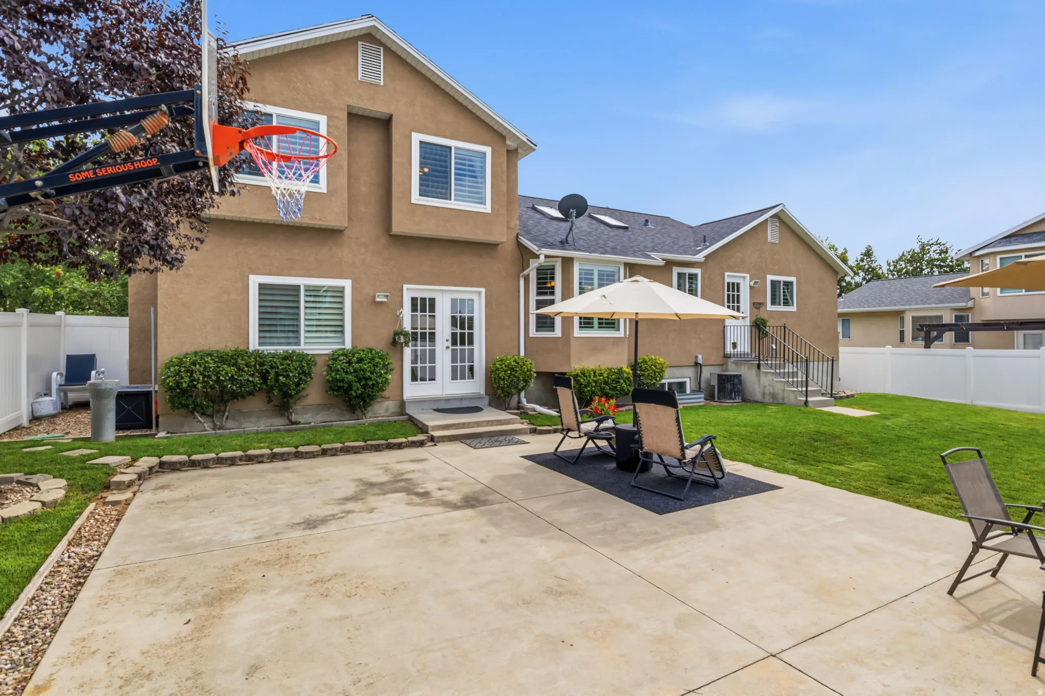 Expansive concrete patio with direct access to interior via double French doors