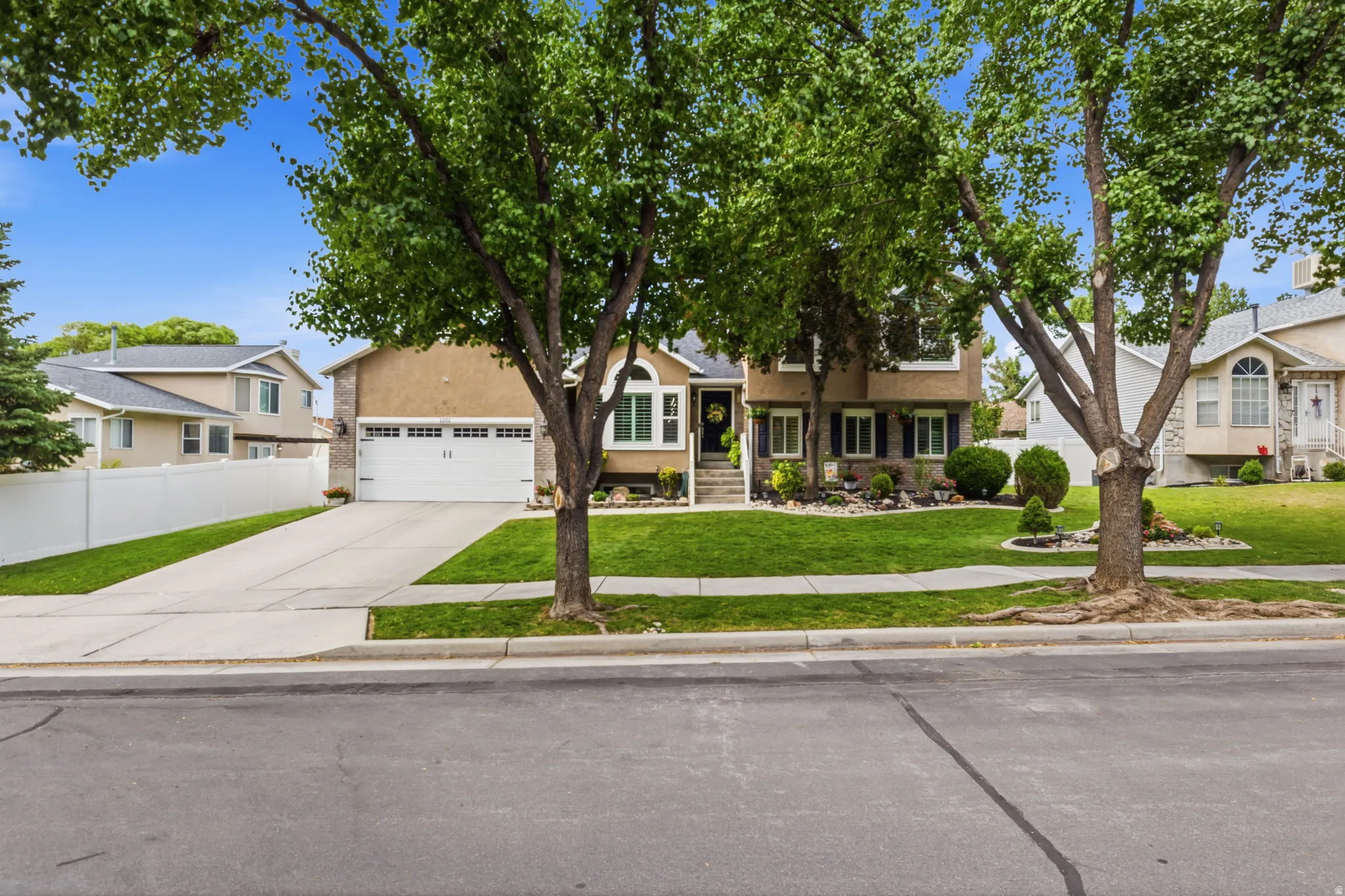 Two-story residence featuring stucco and stone veneer siding, a two-car garage, and a concrete driveway