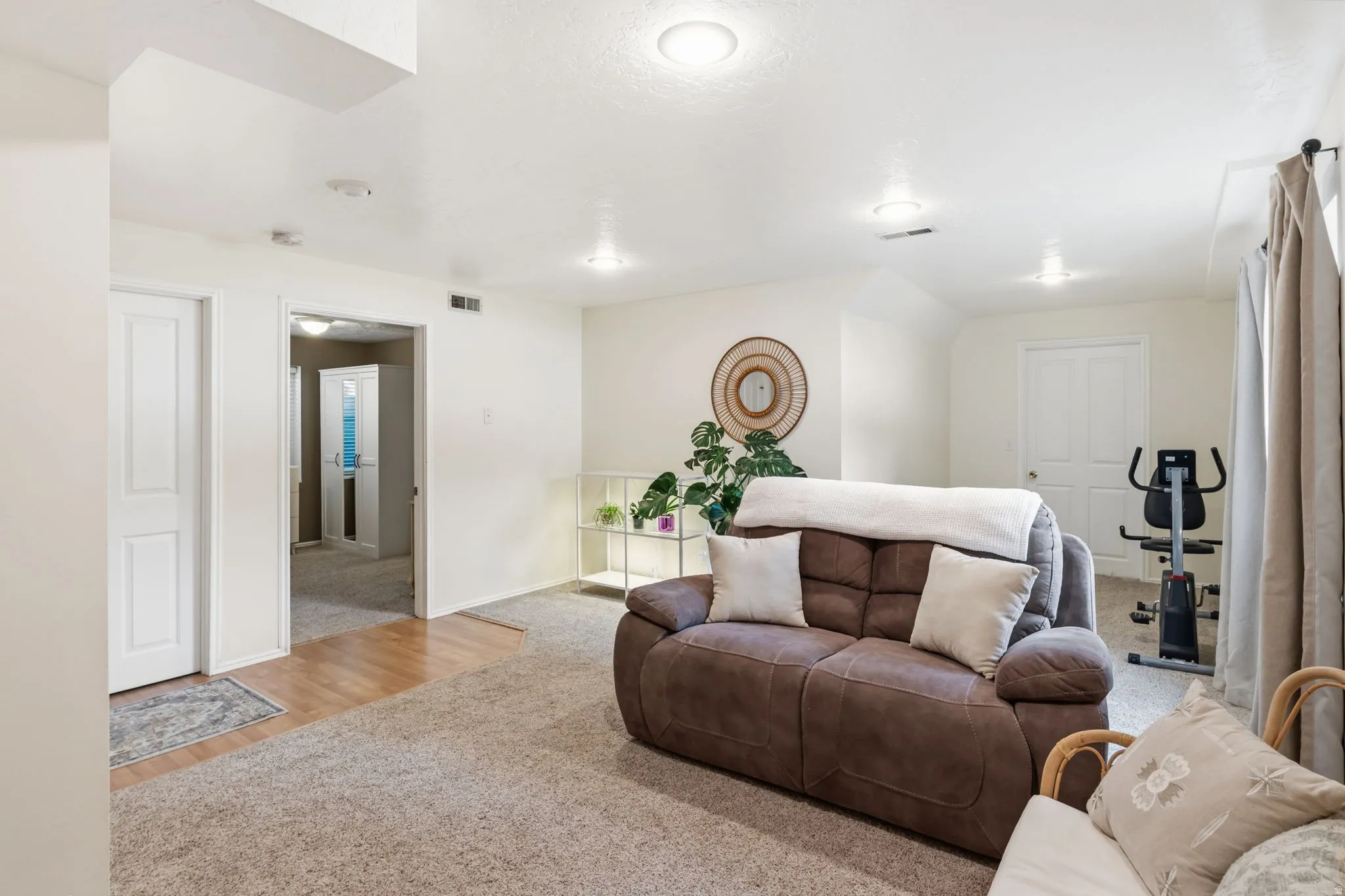 Recessed lighting, carpet flooring, a built-in shelf, and wood-finish flooring in the hallway