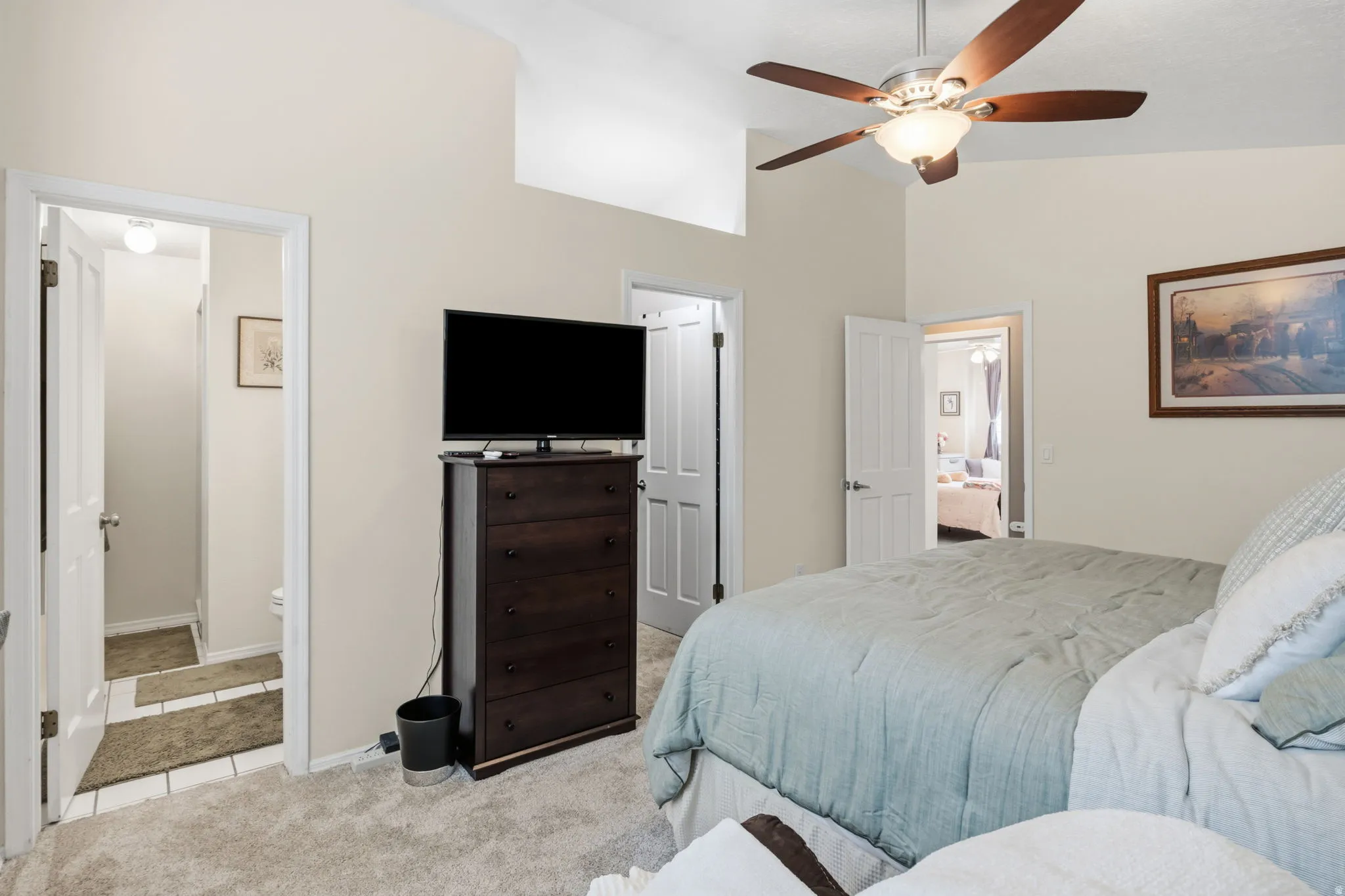 Vaulted ceilings, ceiling fan with integrated lighting, and neutral wall paint