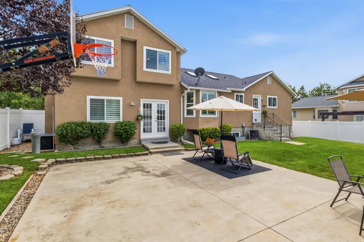 Expansive concrete patio with direct access to interior via double French doors