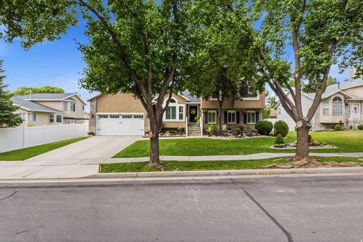 Two-story residence featuring stucco and stone veneer siding, a two-car garage, and a concrete driveway