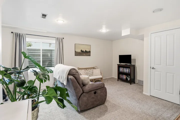 Recessed lighting, wall-to-wall carpeting, and a white interior door with paneling