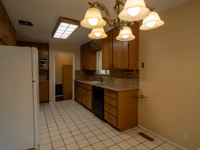 Kitchen featuring wood cabinetry, tiled flooring, built-in appliances, a tiled backsplash, and recessed lighting