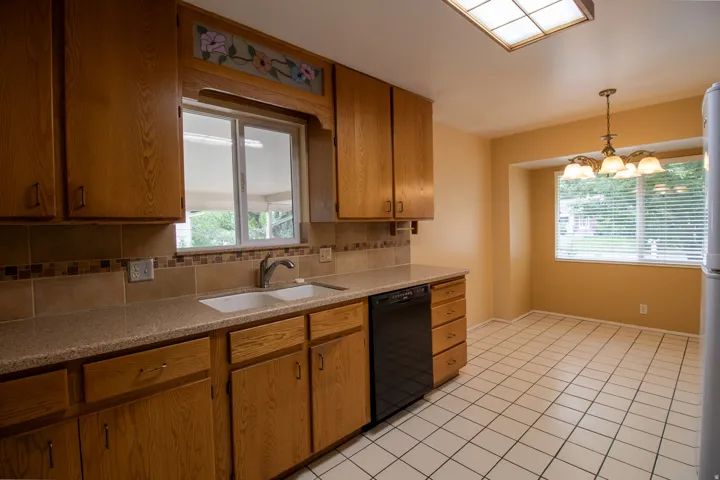Kitchen featuring wood cabinetry, tiled countertops, and a tiled backsplash