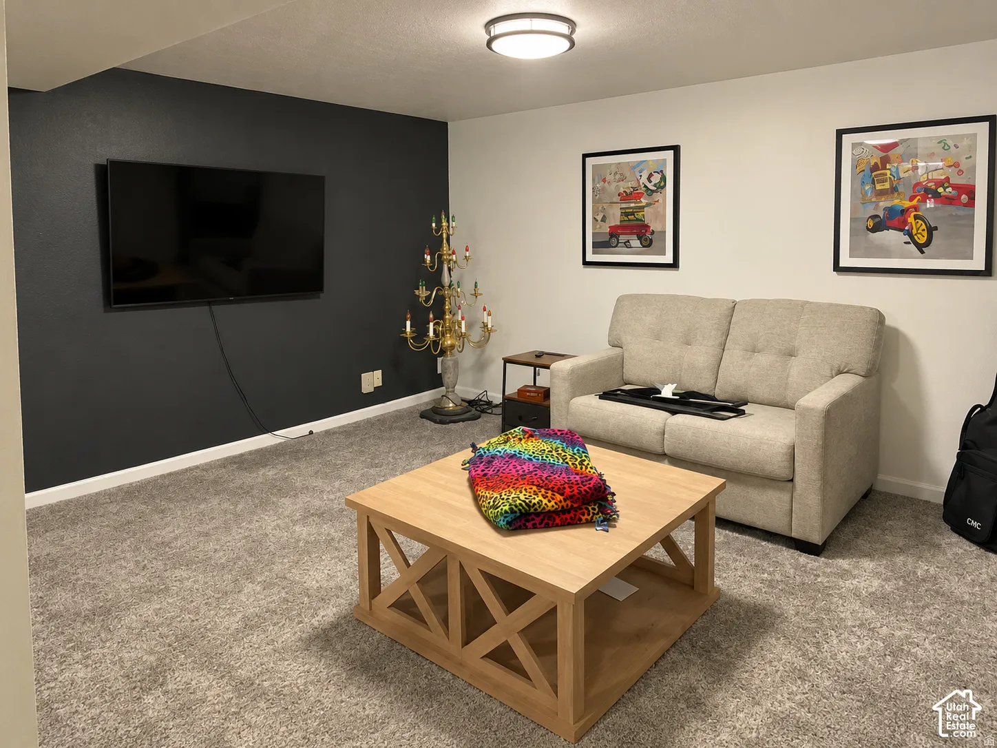Interior space featuring high-contrast charcoal accent wall, neutral carpeting, and a flush-mount ceiling fixture