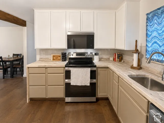 Kitchen featuring two-tone cabinetry, wood-finish countertops, stainless steel appliances, and wood-finish flooring