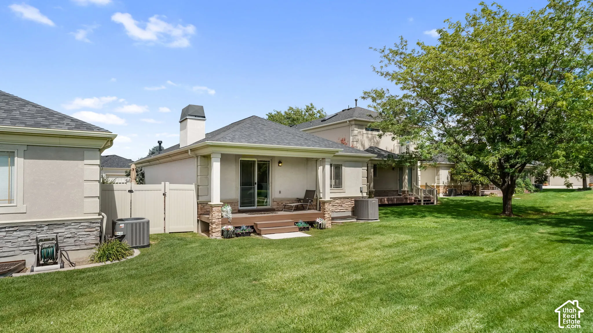 Expansive green lawn with a large mature tree