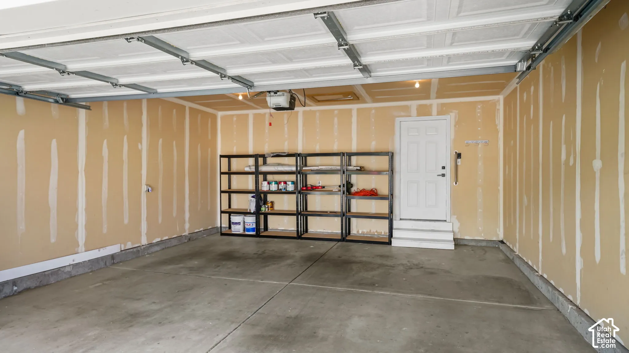 Concrete flooring, exposed wall studs, and a paneled door with steps