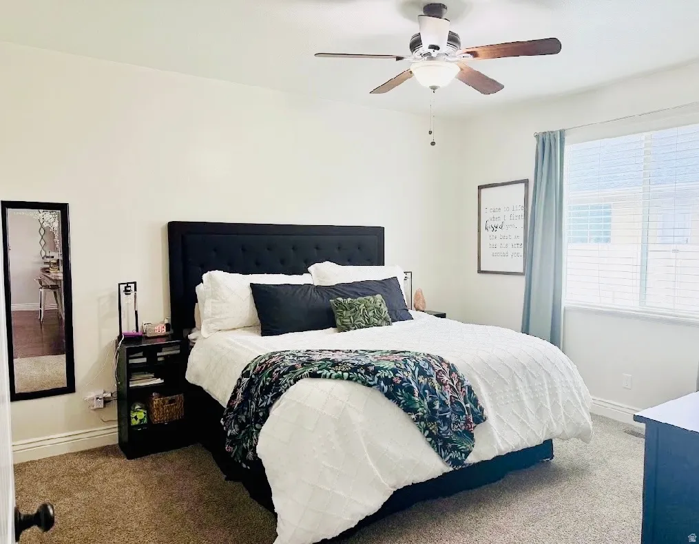 Recessed window with blinds and drapes, ceiling fan with integrated lighting, and neutral wall paint