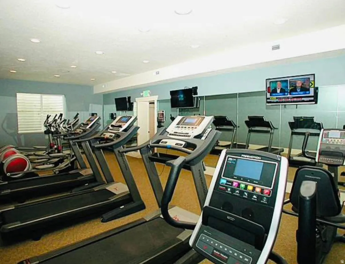 Fitness center featuring multiple treadmills, exercise bikes, and wall-mounted televisions