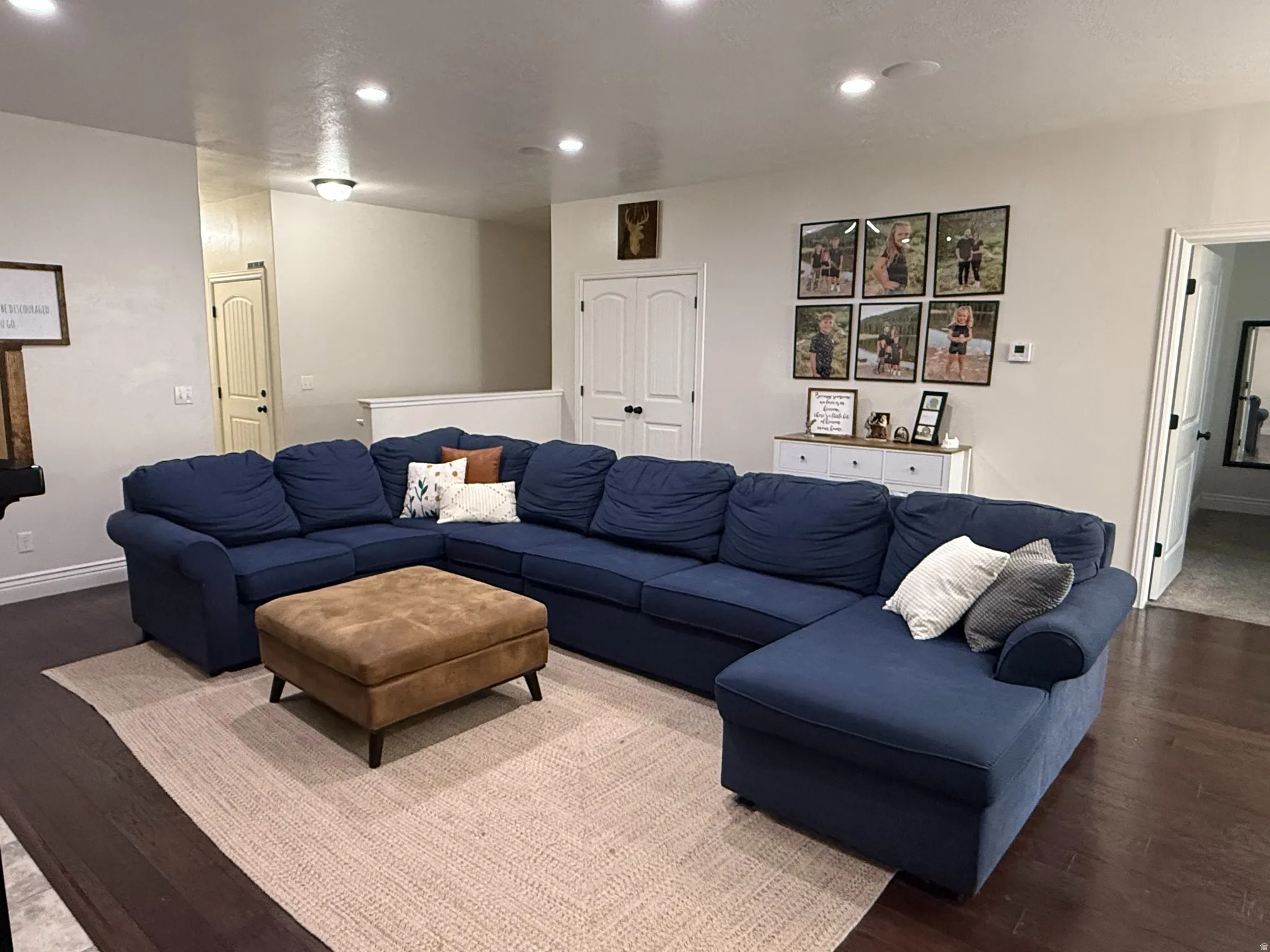 Recessed lighting, wood-finish flooring, white wall paint, door frames, and built-in fireplace mantel