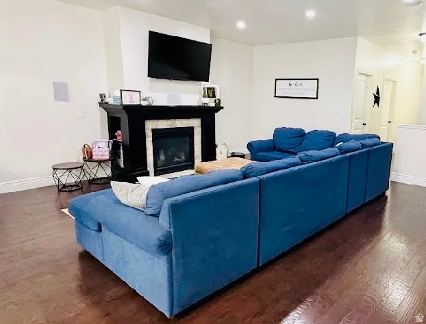 Hardwood-finish flooring throughout, featuring a fireplace with a stone surround and dark wood mantel