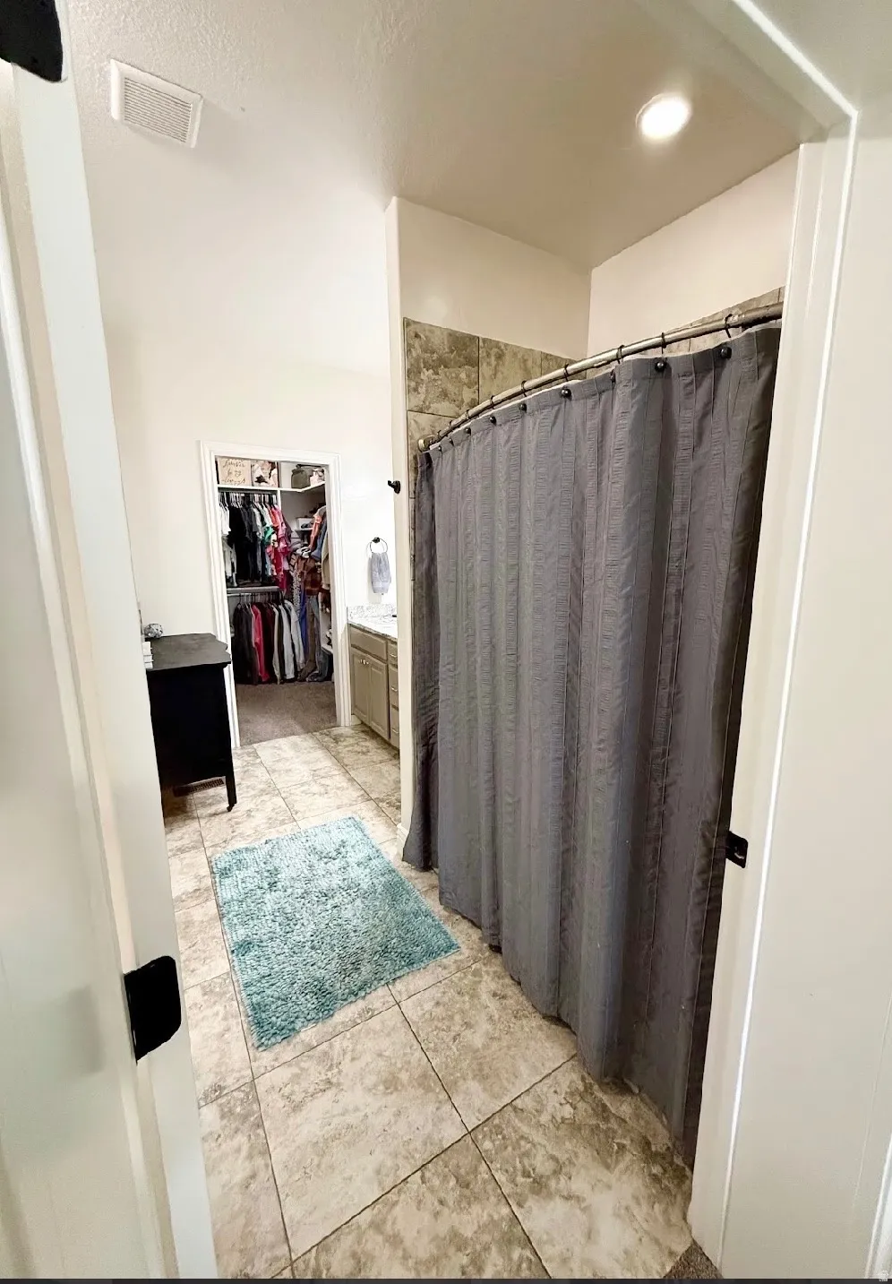 Tiled flooring, recessed ceiling lighting, and a shower with tile surround