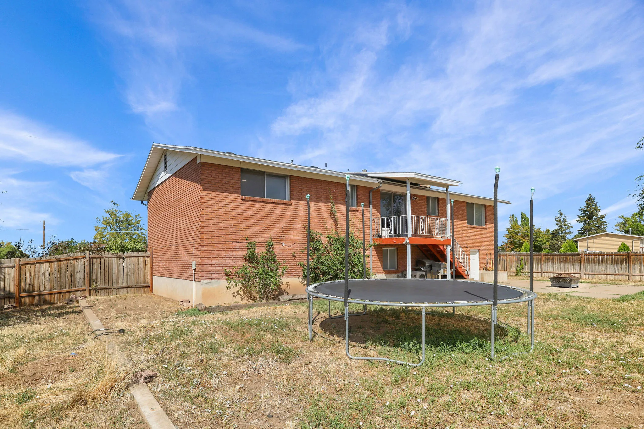Red brick exterior with white trim, featuring a covered balcony