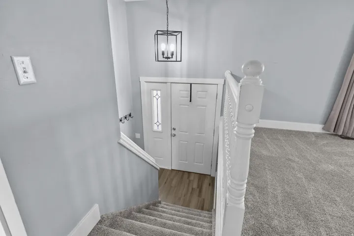 Carpeted staircase with white balusters