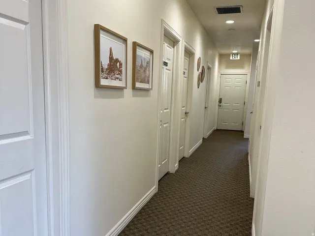 Recessed ceiling lighting, patterned carpet flooring, and white paneled doors